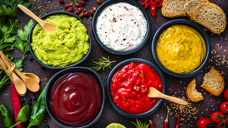 Assortment of dips in bowls with ingredients on the side