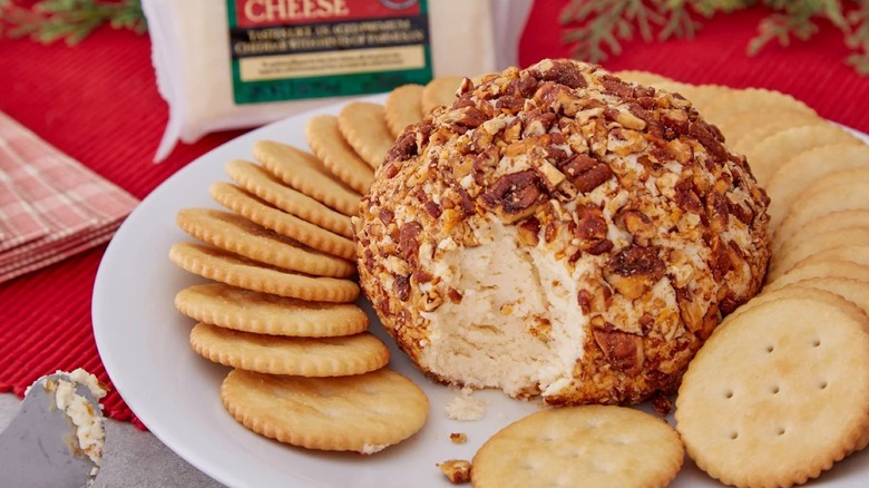 Trader Joe's Unexpected Cheddar product covered in nuts on plate with crackers