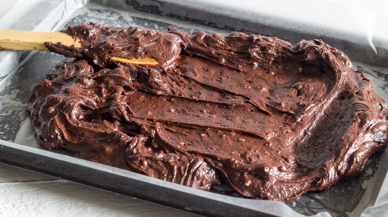 spreading brownie batter in pan