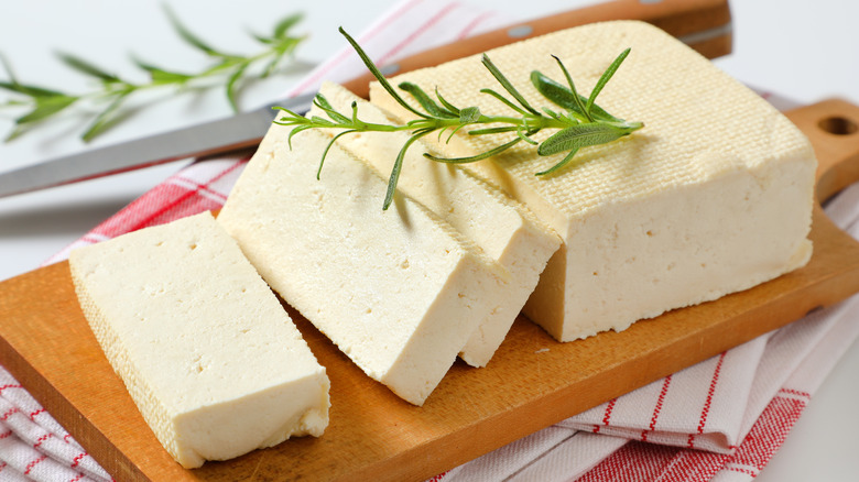 A block of firm tofu on a cutting board