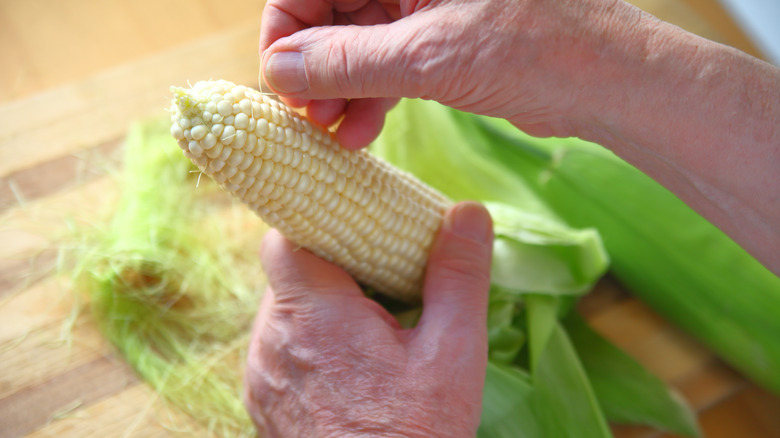 Hand removing corn silk