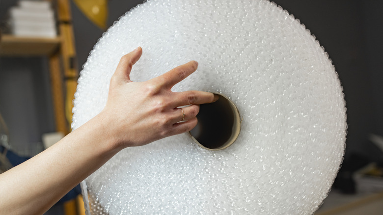 person holding bubble wrap roll