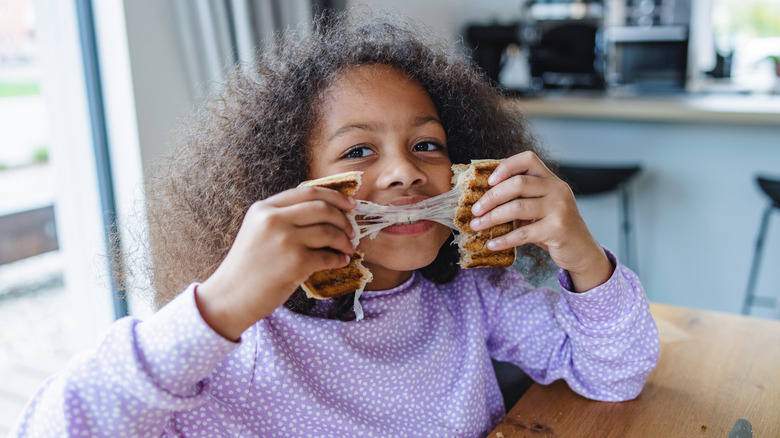 girl pulling grilled cheese