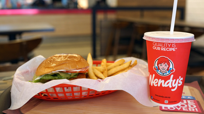 A Wendy's burger and a drink on a tray