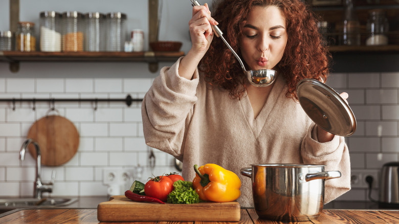 woman blowing on soup ladle