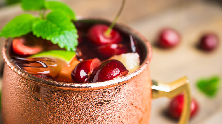 Cherry moscow mule in gold cup with mint garnish
