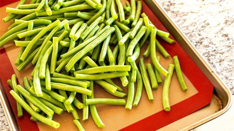 Raw green beans on sheet pan 