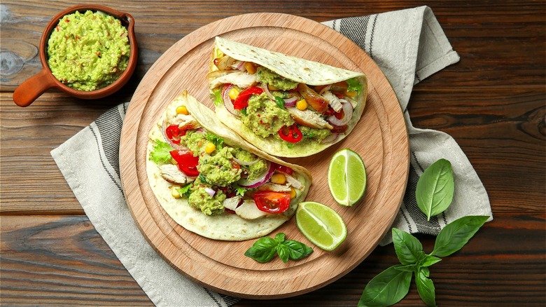 Tacos with tomatoes, guacamole, and lime 