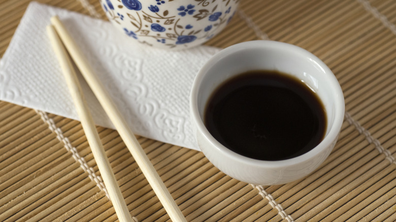 bowl of soy sauce with chopsticks