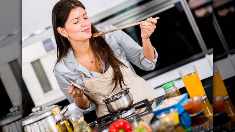 woman tasting tomato sauce