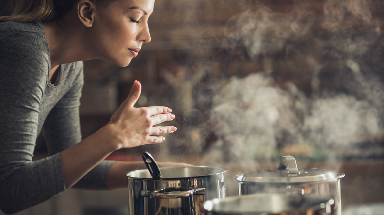 woman smelling while cooking