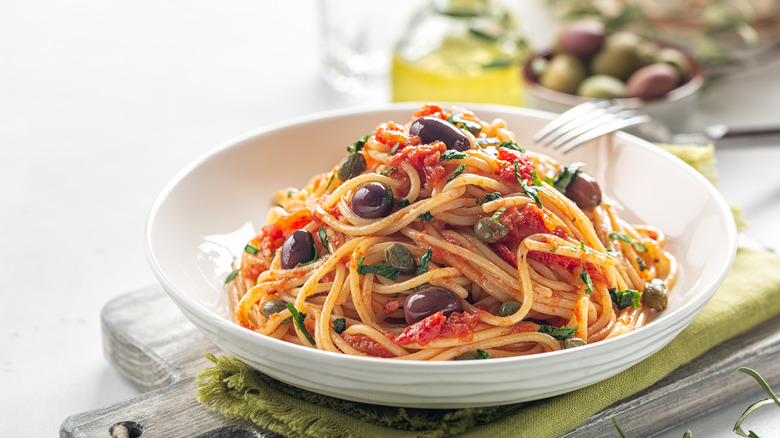 spaghetti puttanesca in white bowl