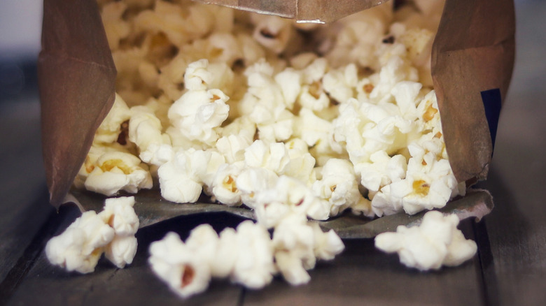 popcorn spilling from microwave bag