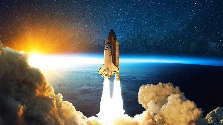 Space shuttle launching into space with sunset