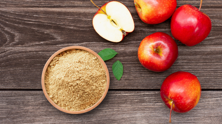 bowl filled with apple powder next to red apples