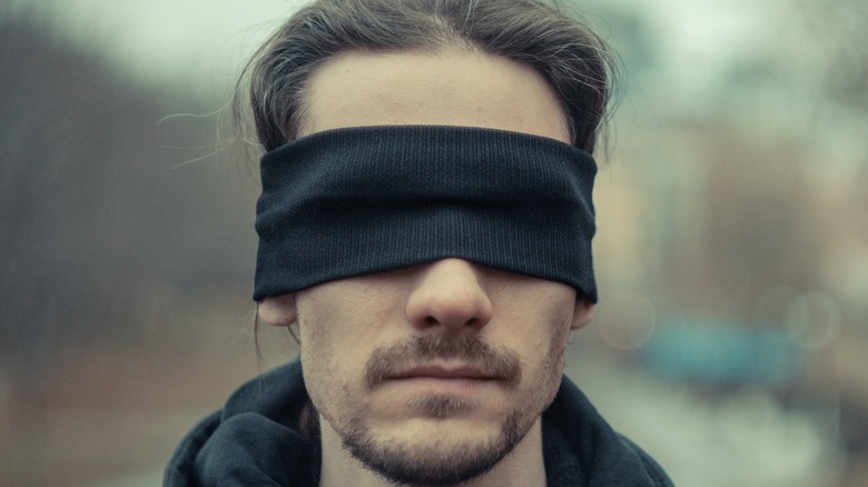 man wearing black blindfold