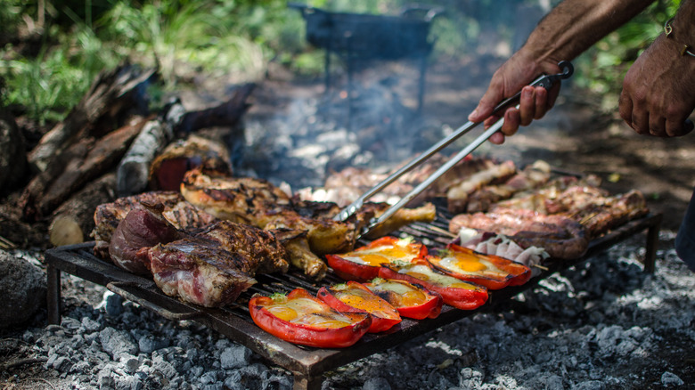 person grilling meat and vegetables