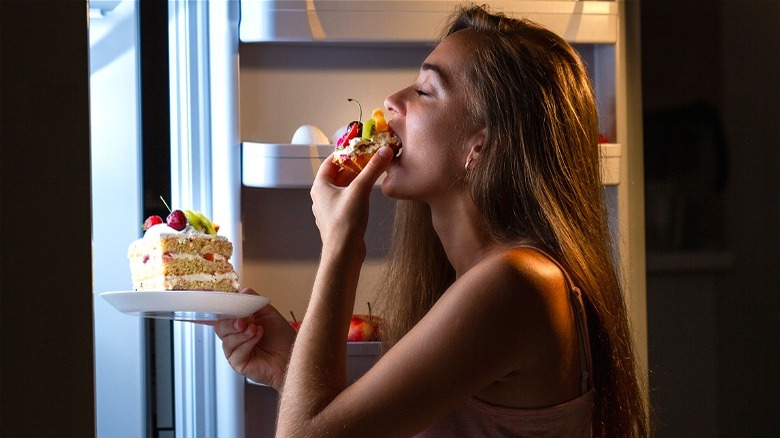 Person eating cake with eyes closed