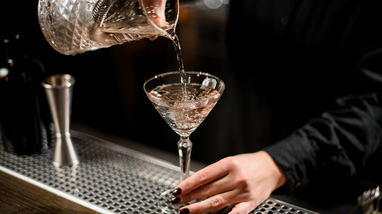 bartender pouring martini into glass