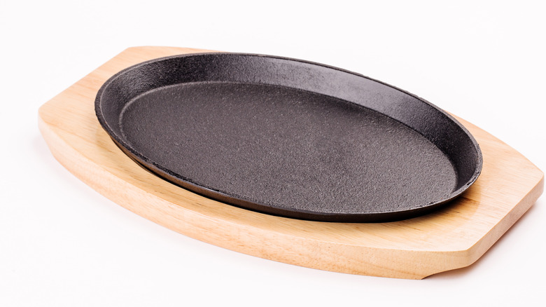 empty sizzle platter on a wooden board