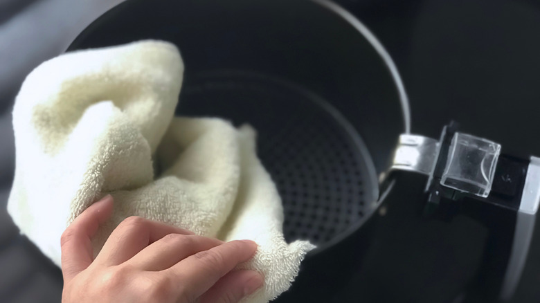 wiping air fryer basket with cloth