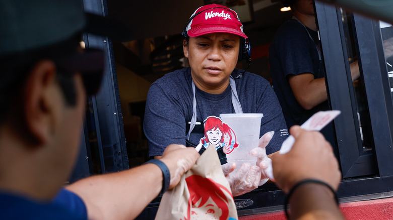 Wendy's worker helping drive-thru customer