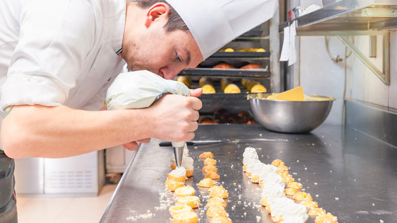 A pastry chef making cream puffs