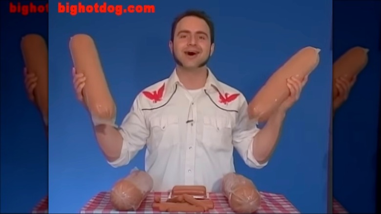 person hold two big hot dogs