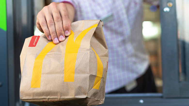 McDonald's employees handing bag of food