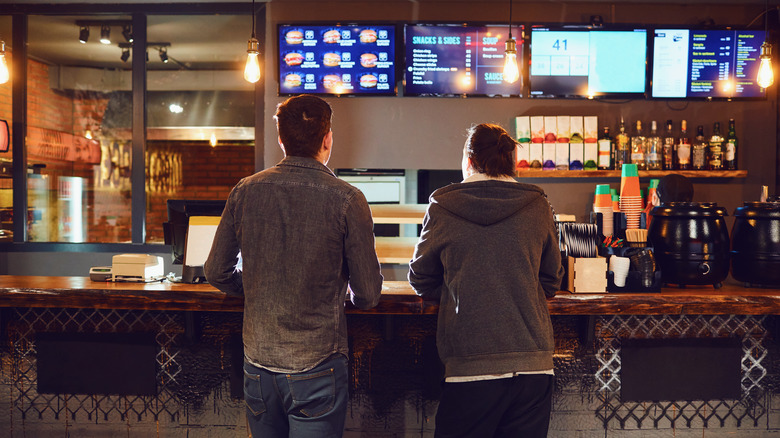 Two men standing at the counter in a fast-food restaurant