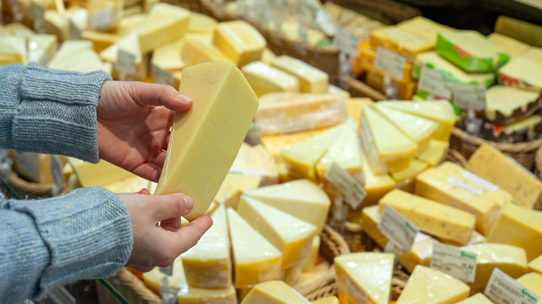 selecting cheese in a grocery store