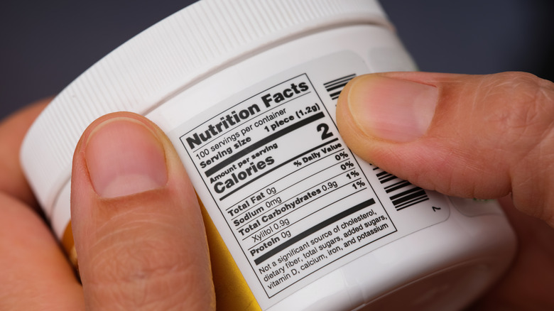 Hand checking nutritional label on food product