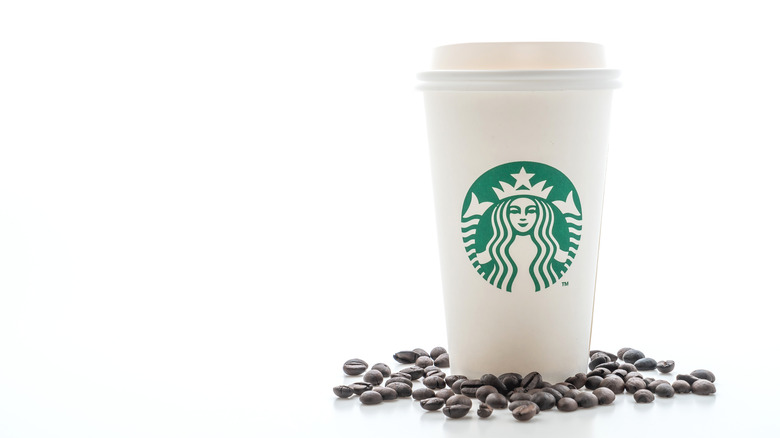 Starbucks drink surrounded by coffee beans 