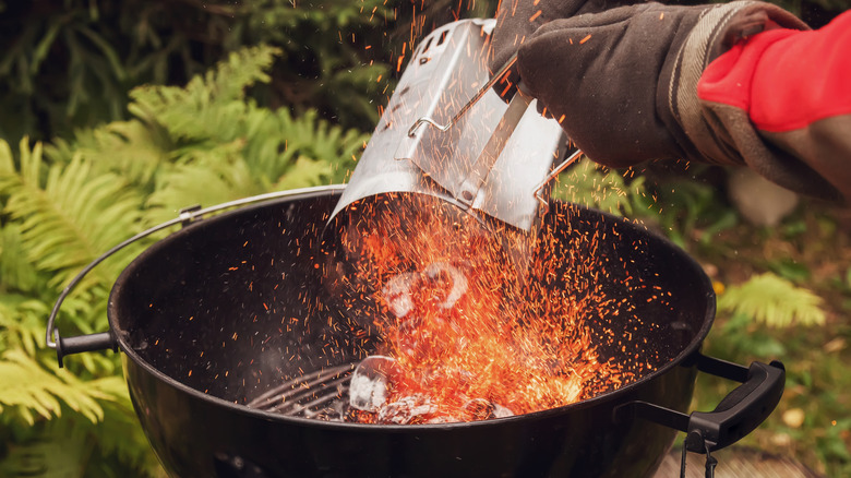 chimney starter pouring coals into grill