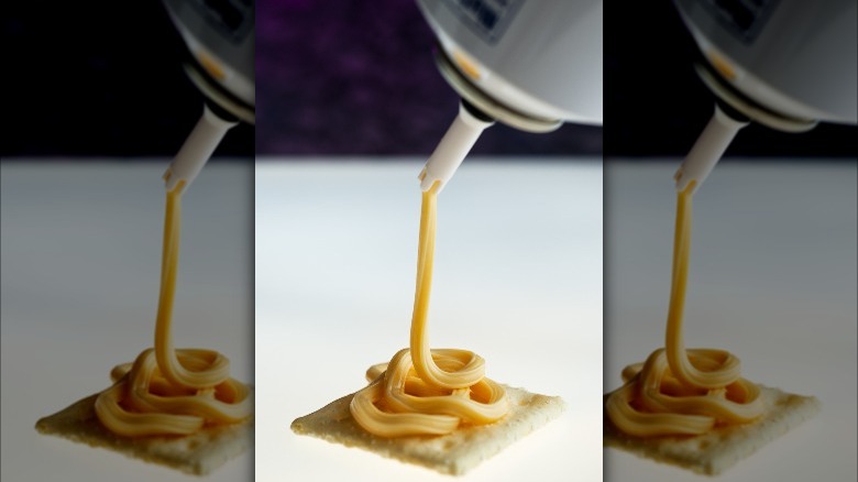 Spray cheese on cracker