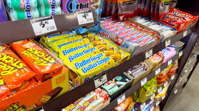 Various types of packaged chocolates on display by a grocery store counter