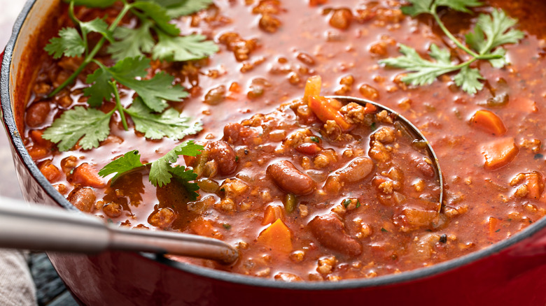 ladling chili from large pot