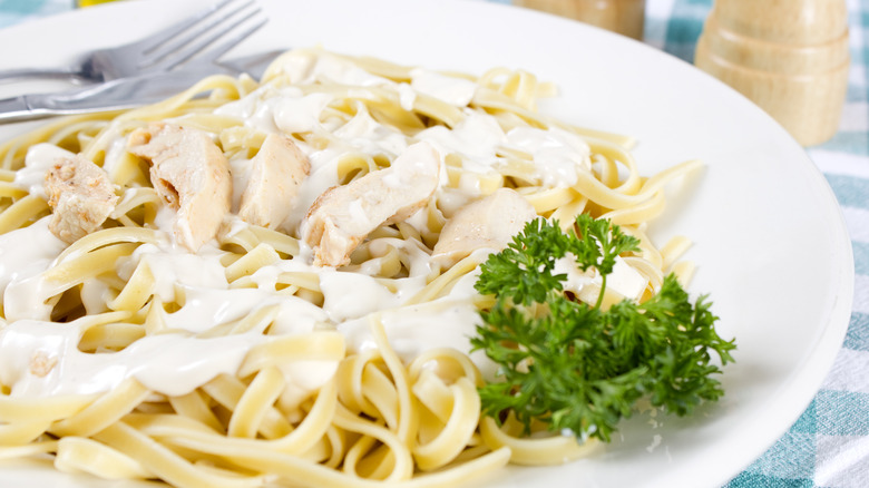 Closeup of plated pasta with cream sauce and parsley