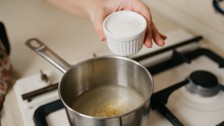 Adding mayonnaise to pot