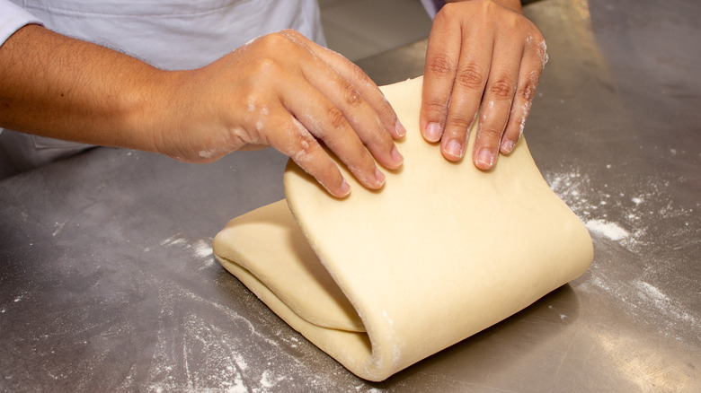 hands folding puff pastry