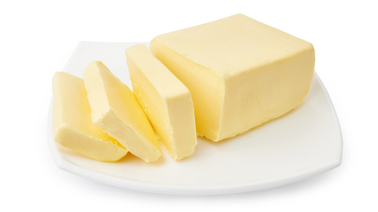 Sliced brick of butter on plate