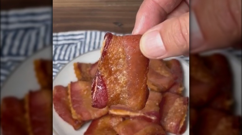 Hand holds bacon cracker