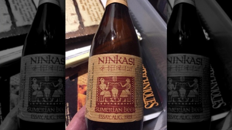 A hand holding Ninkasi Sumerian beer