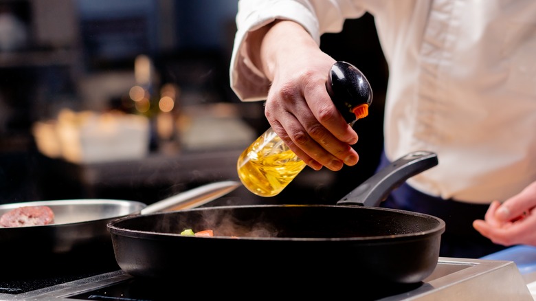 chef spraying cooking oil 