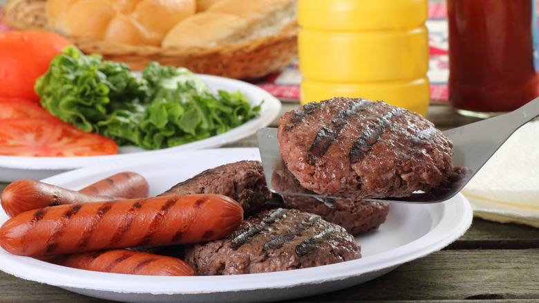 grilled burgers and hot dogs on table, spatula