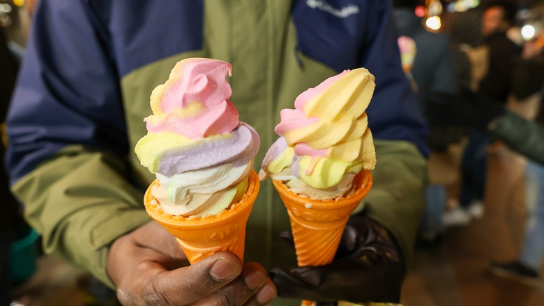 person holding two ice cream cones