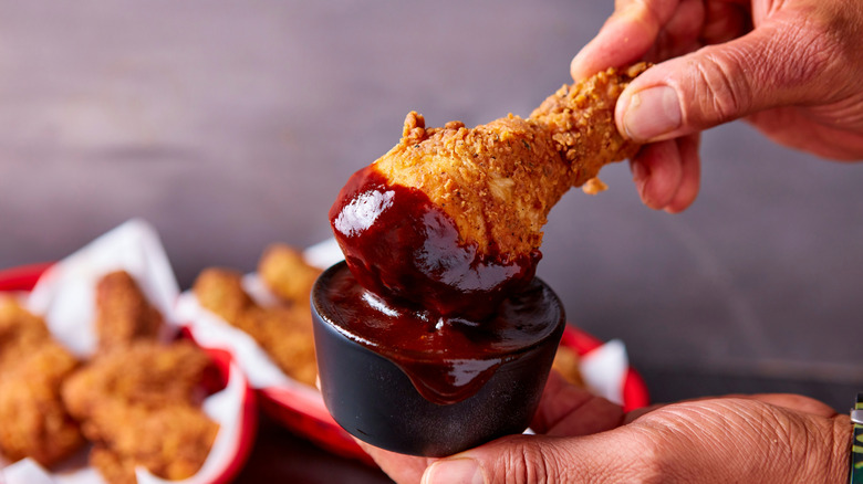 Dipping fried chicken in barbecue sauce