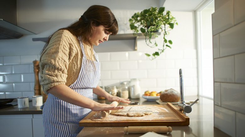 woman rolling dough in kitchen