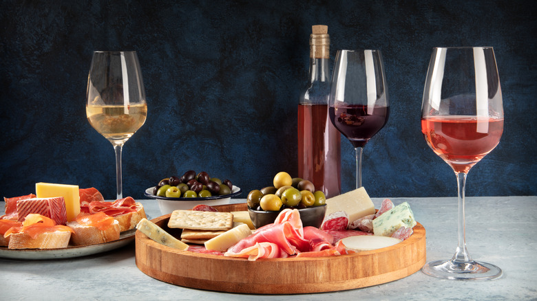 Charcuterie board with olives and wine