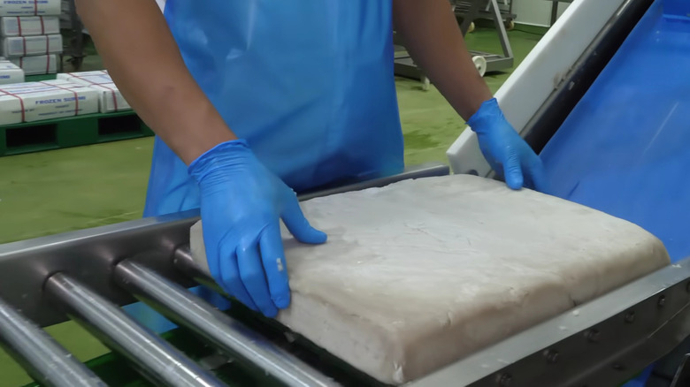 Block of surimi being handled